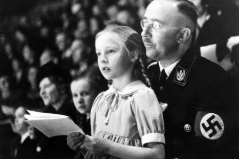 From right: Chief of the German Police and Minister of the Interior Heinrich Himmler with his daughter Gudrun on his lap watch an indoor sports display in Berlin, on March 6, 1938.